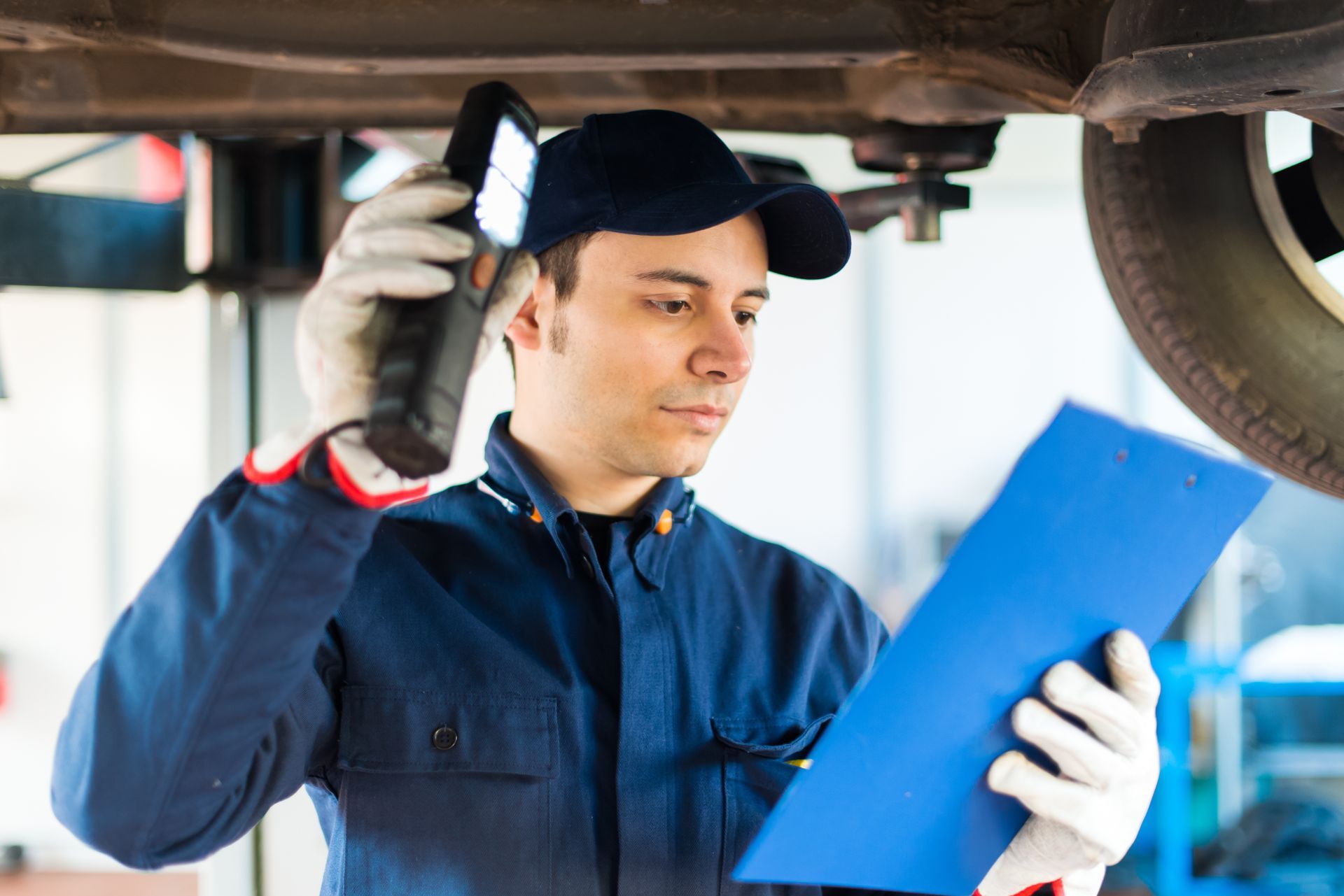 Mécanicien qui inspecte le dessous d'une voiture