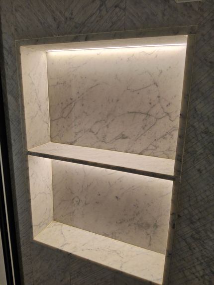 Une étagère en marbre avec une lumière à l'intérieur.