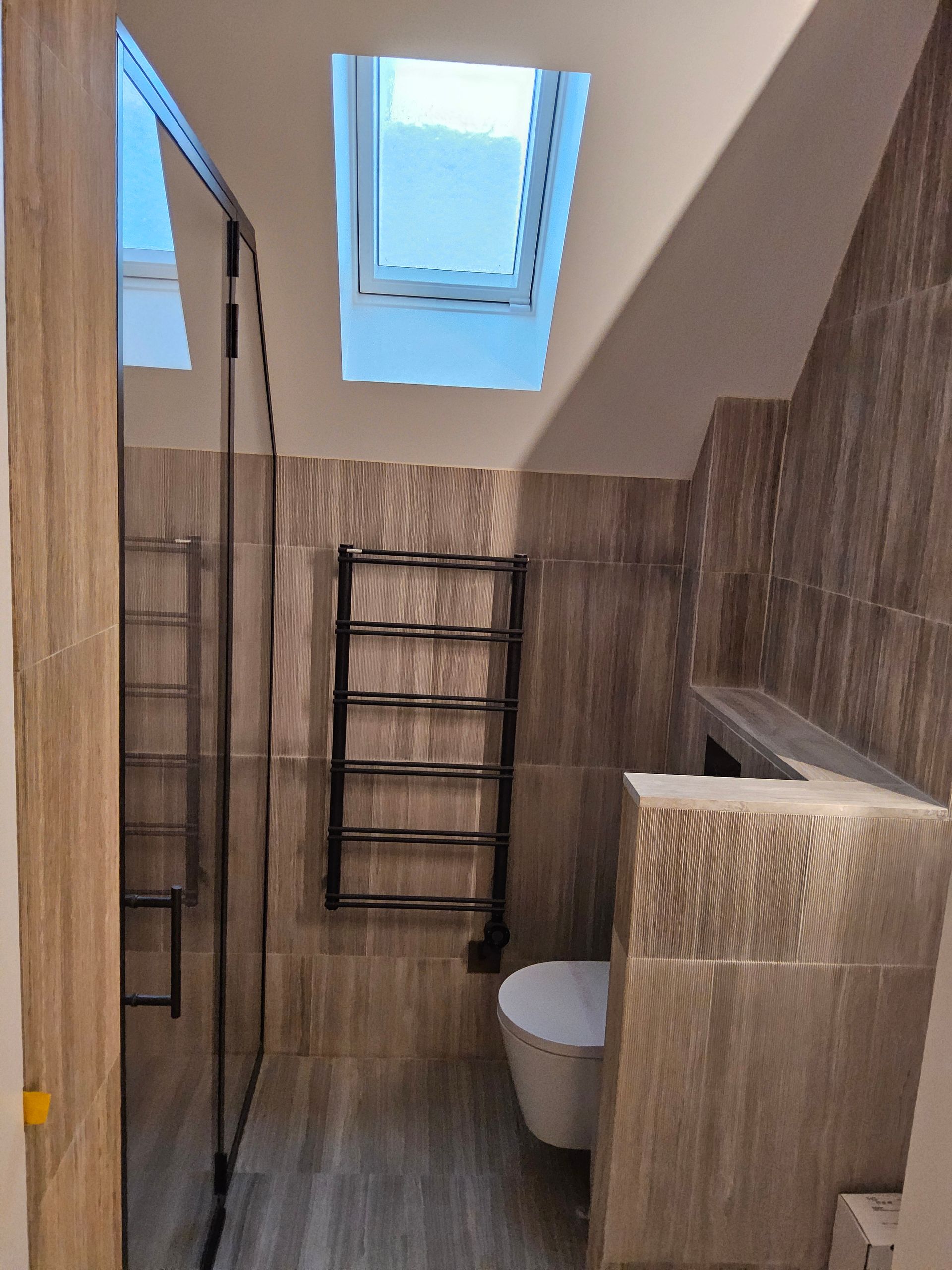 Une salle de bain avec toilettes et un puits de lumière au-dessus