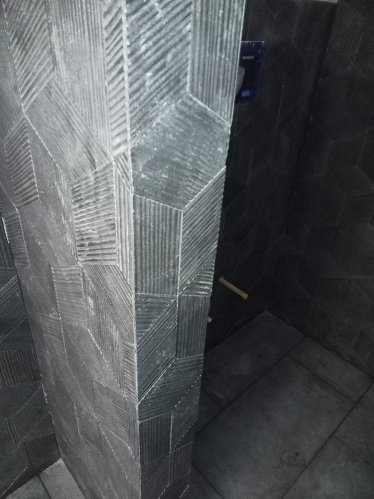 Un gros plan d'un mur carrelé dans une salle de bain.