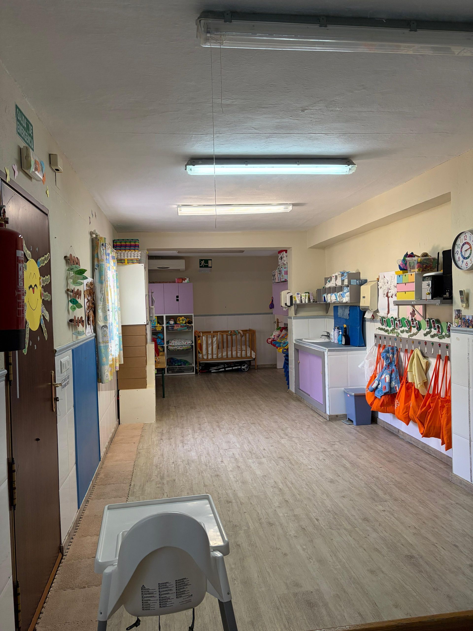 Aula vacía con arte de árbol, valla de madera, mesa y decoraciones.