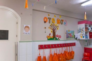 Pared de jardín de infancia con temática otoñal: árbol, bolsas naranjas y