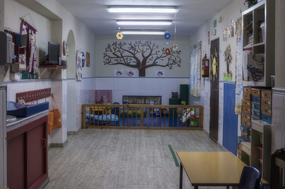 Aula vacía con arte de árbol, valla de madera, mesa y decoraciones.