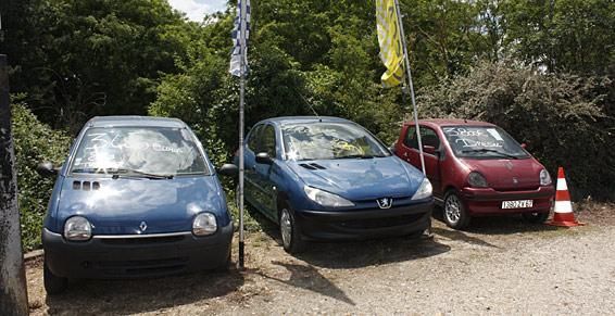 Trois petites voitures : une Renault Twingo bleue, une Peugeot 206 bleue et une Renault Clio rouge, garées côte à côte.