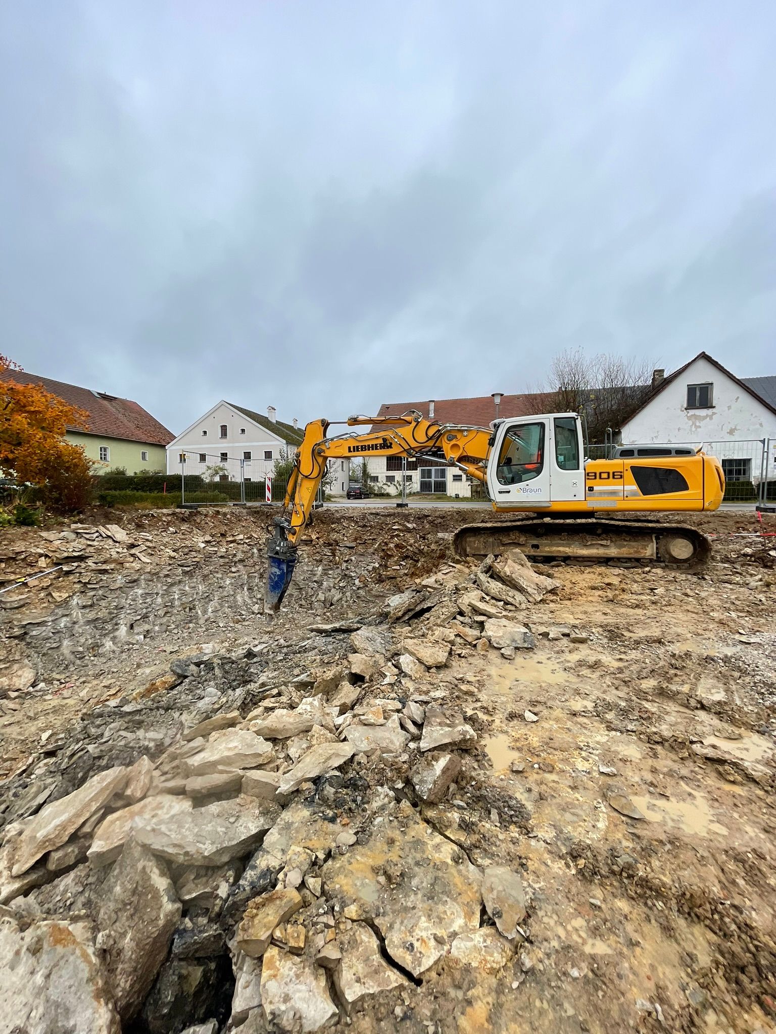 Erdarbeiten im Wohngebiet mit Bagger und Lkw