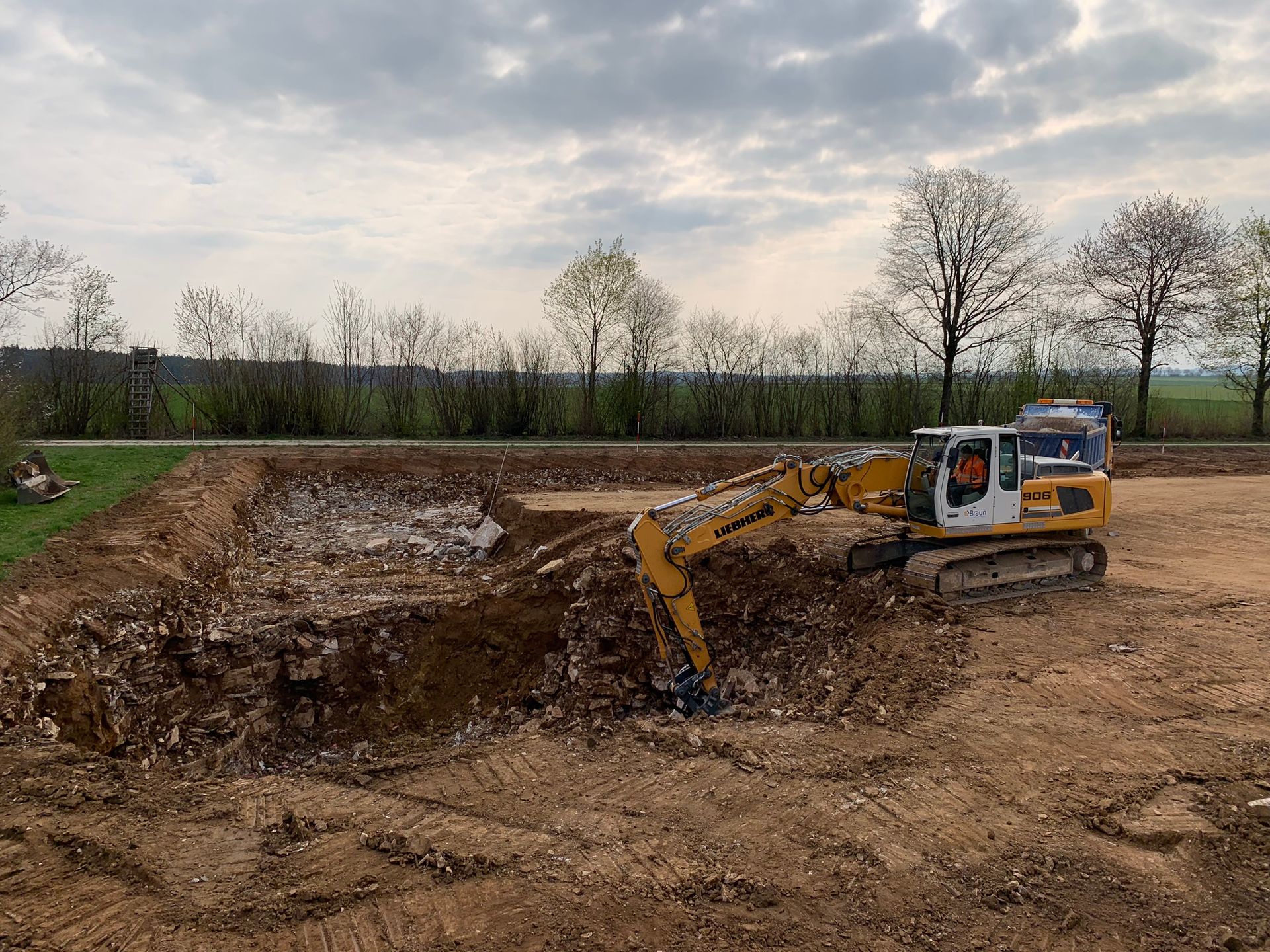 Baugrube mit Bagger für Erd- und Wegebaumaßnahmen