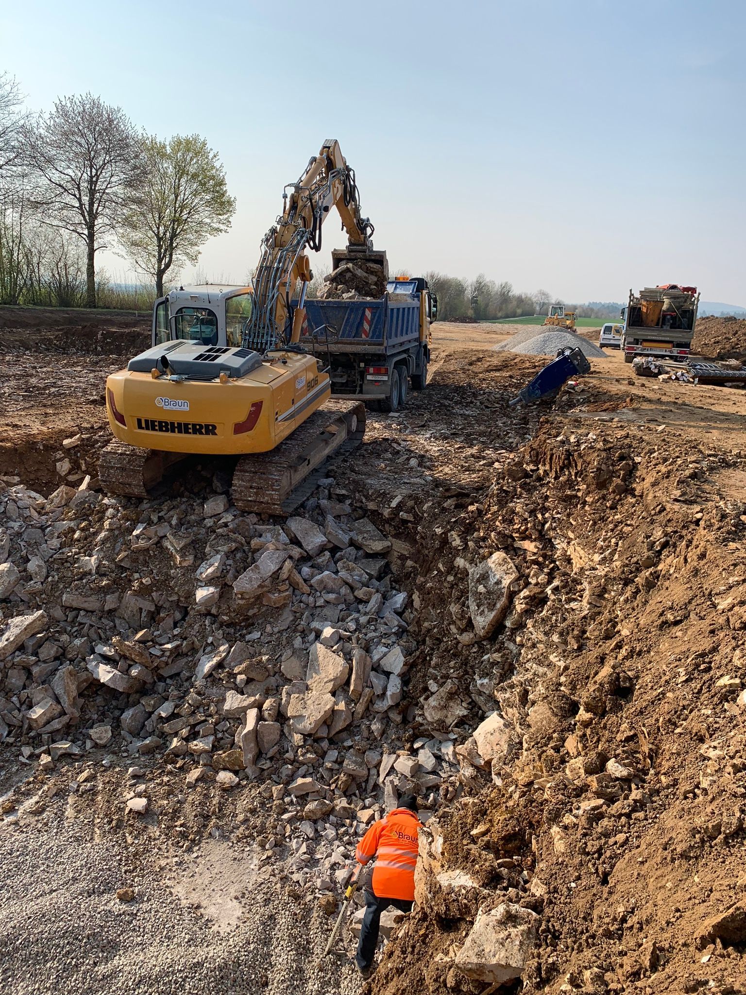 Erdarbeiten mit Bagger und Lkw auf Großbaustelle