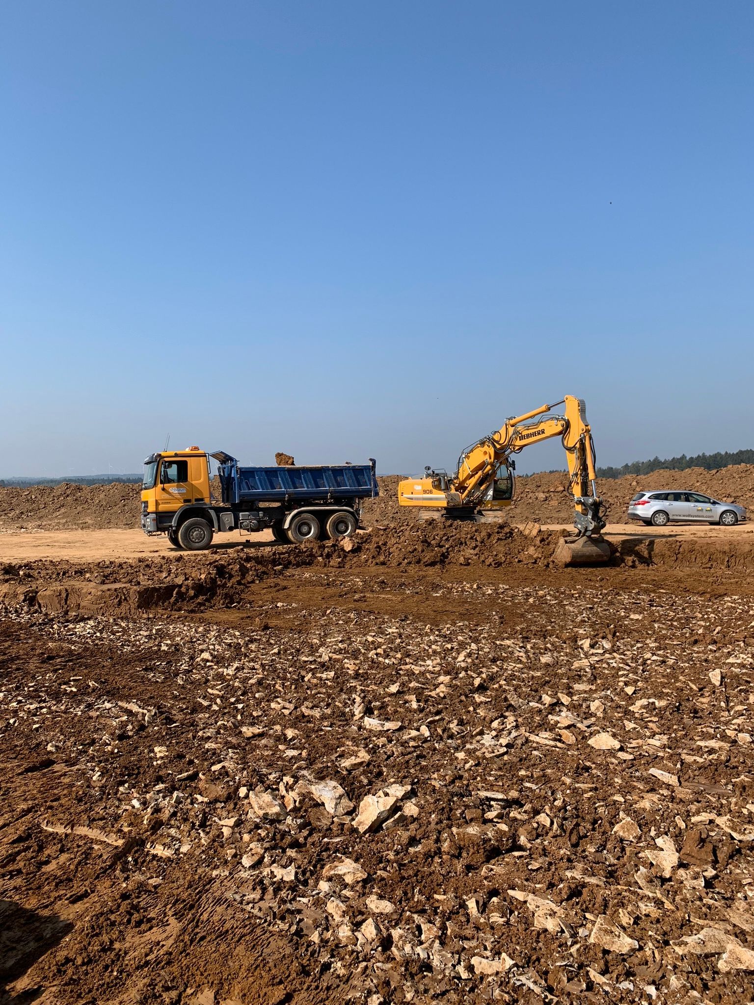 Bagger vor blauem Himmel auf Erdbaustelle