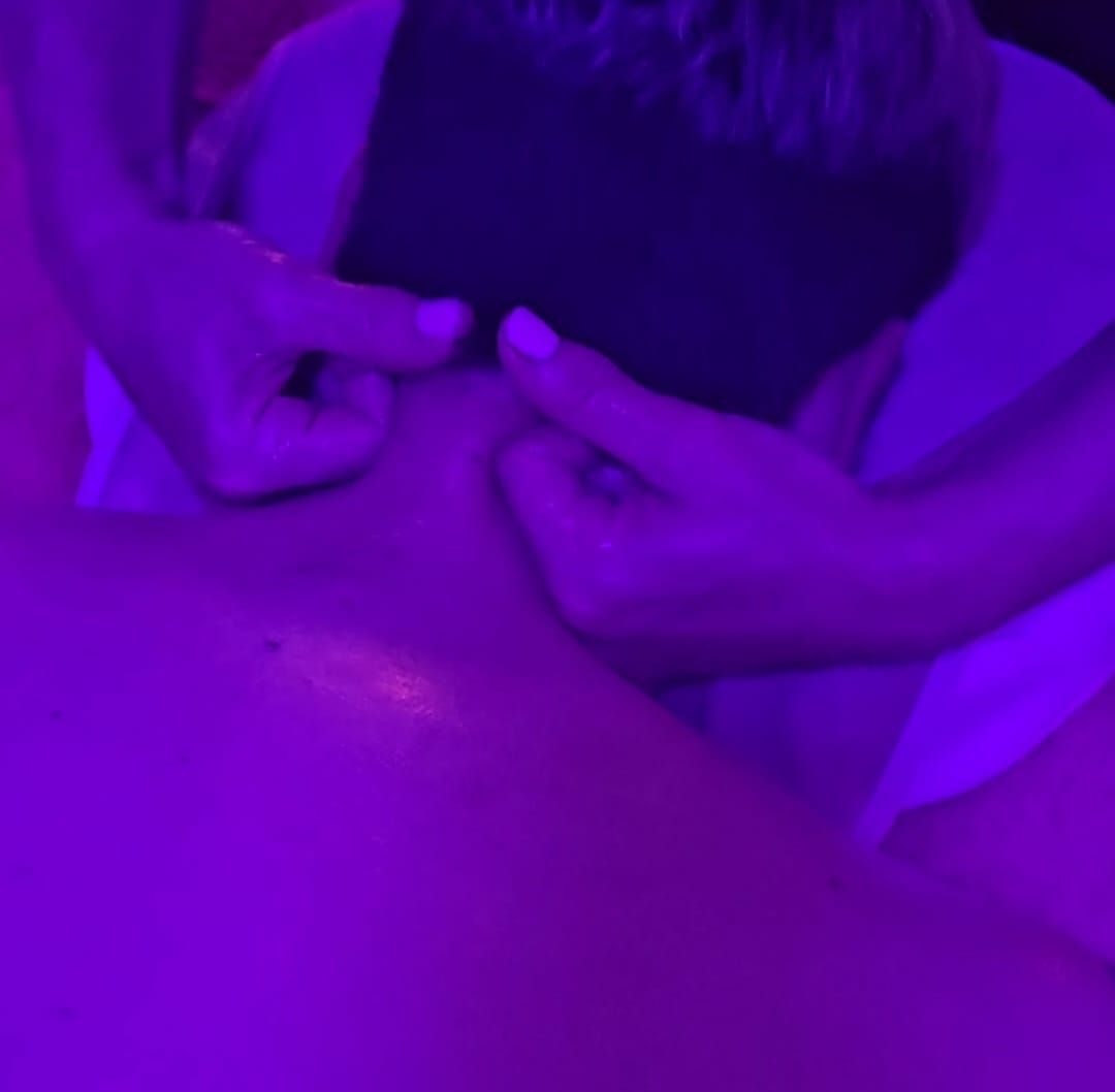Manos presionando alrededor del ojo de una persona bajo luz violeta