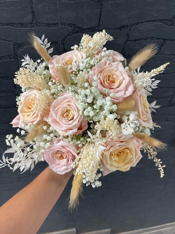 Eine Person hält einen Blumenstrauß in der Hand.