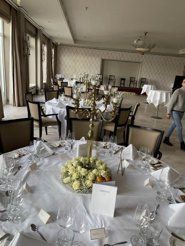 Ein großer Raum mit Tischen und Stühlen für einen Hochzeitsempfang.