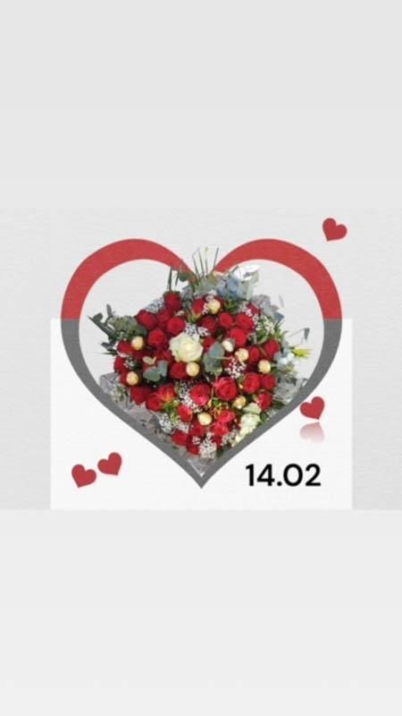 Ein Strauß roter und weißer Blumen in einem herzförmigen Rahmen.