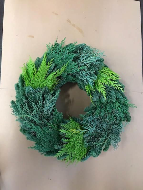 Ein grüner Kranz sitzt auf einem Stück Pappe