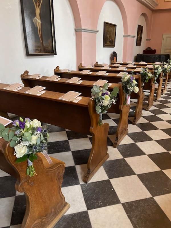 Eine Reihe von Holzbänken in einer mit Blumen geschmückten Kirche