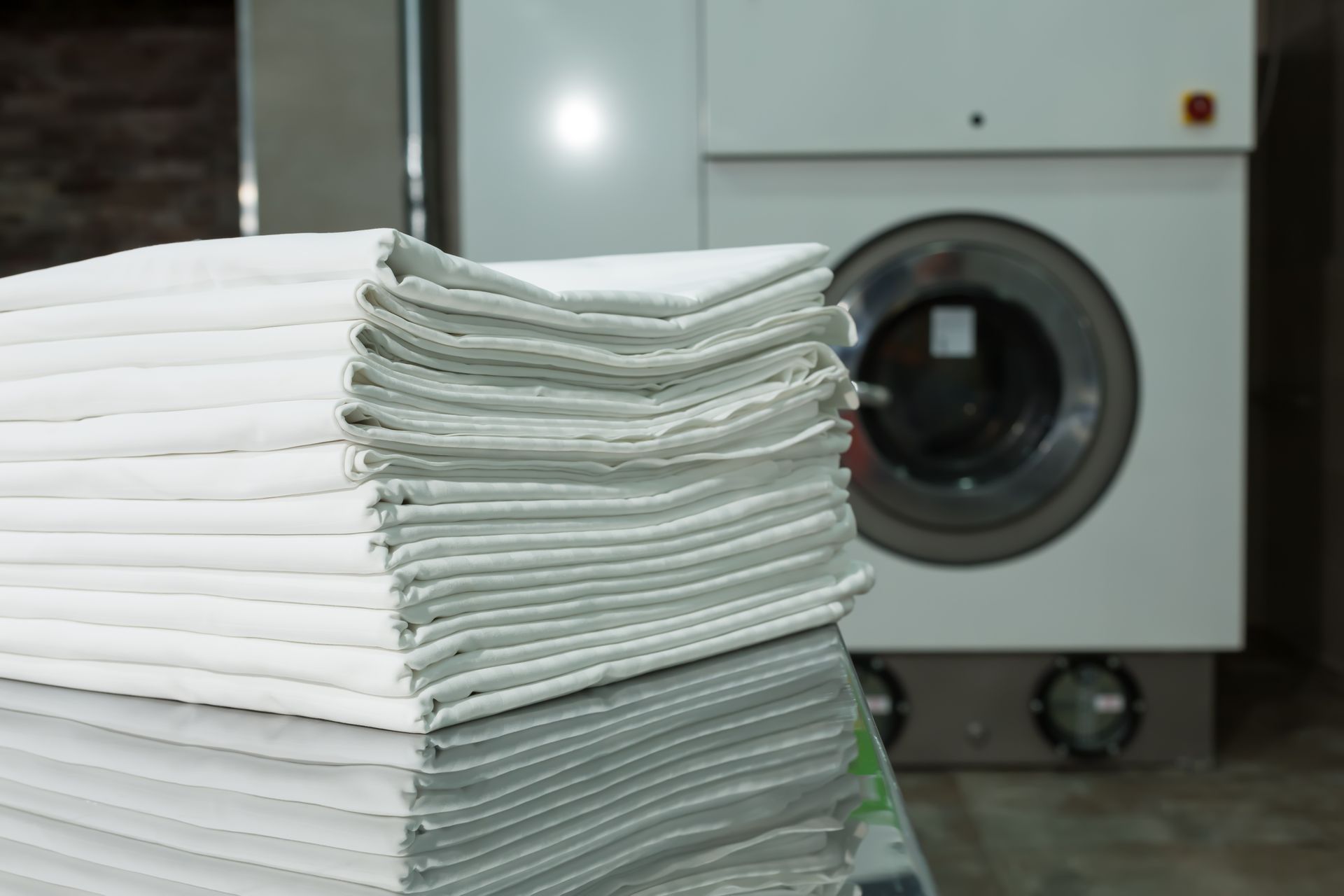 Du linge plié devant une machine à laver.