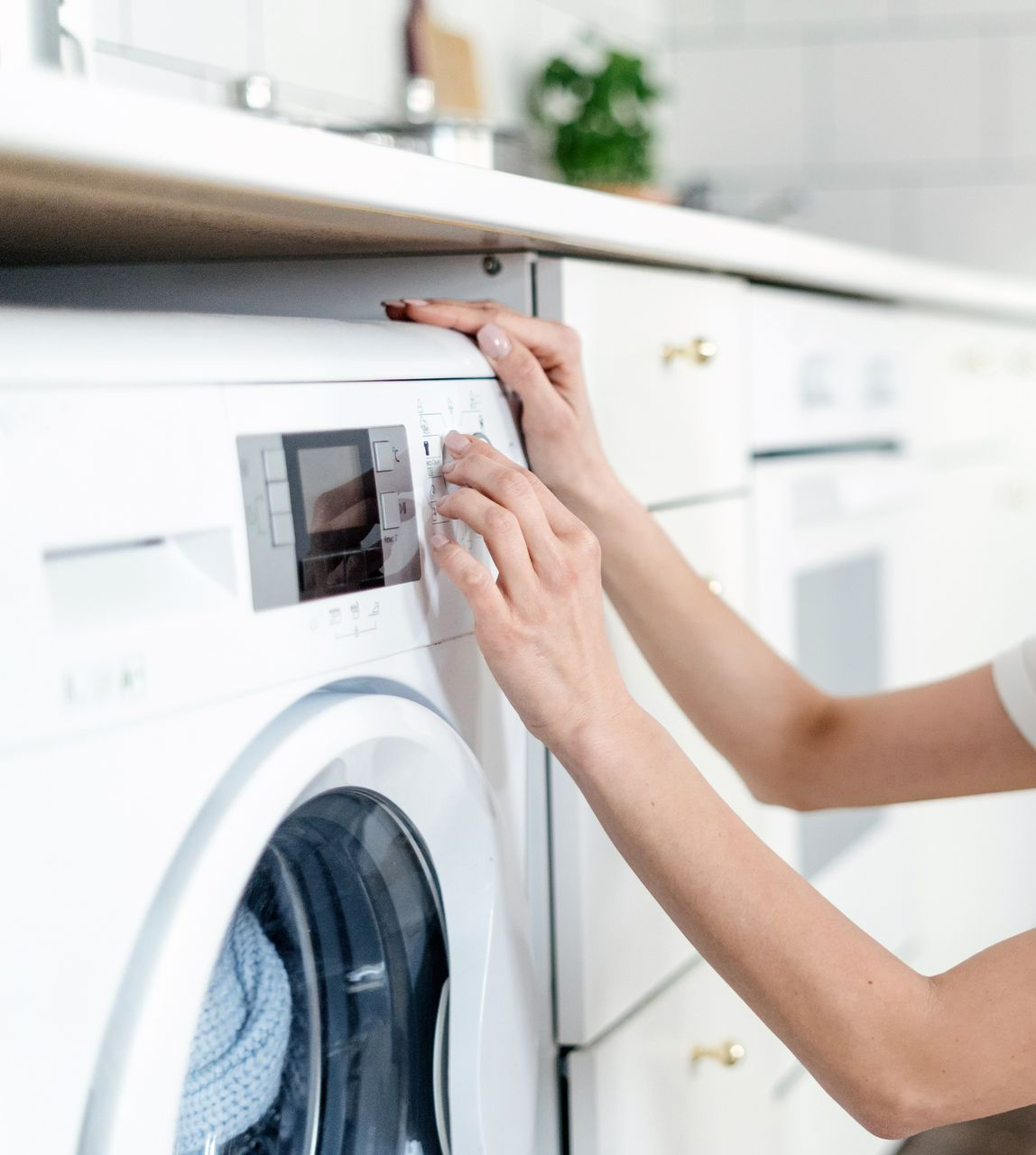 Une femme en train de lancer une machine à laver.