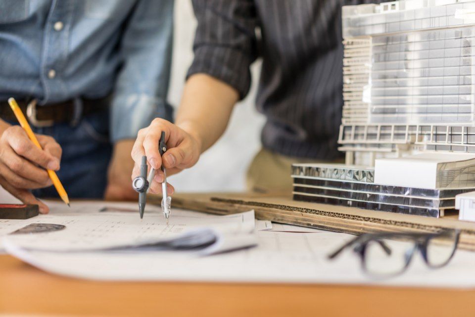 Menschen bearbeiten Skizzen von Miniaturhaus