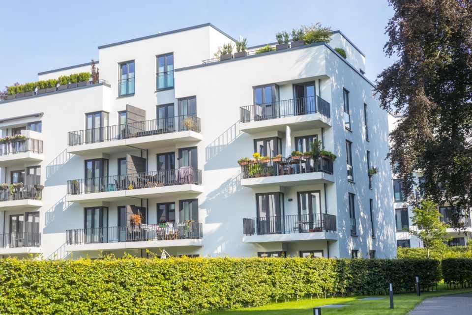 Weißer Wohnkomplex mit Grünanlage