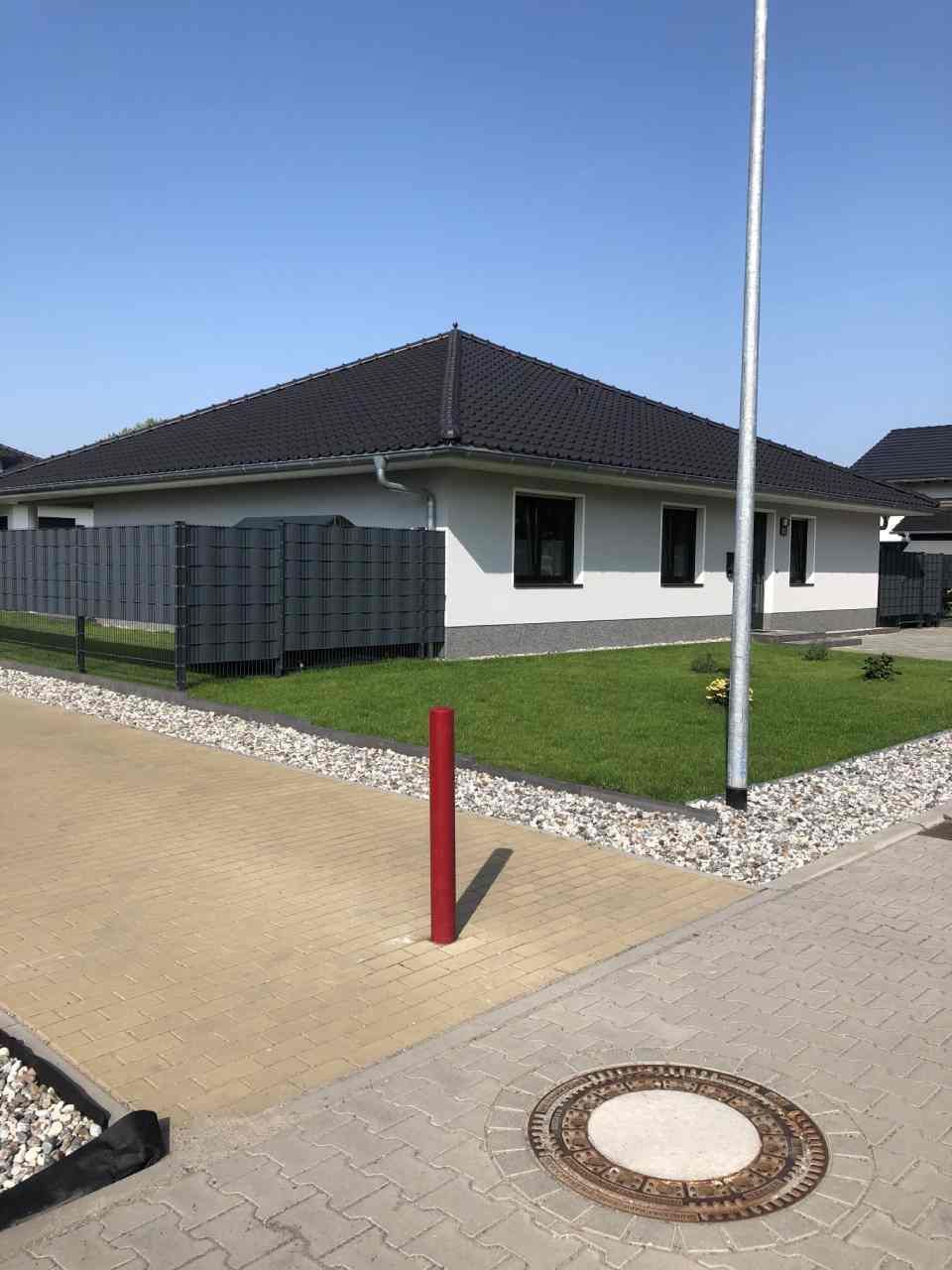 Neubau Einfamilienhaus als Bungalow mit weißer Fassade.