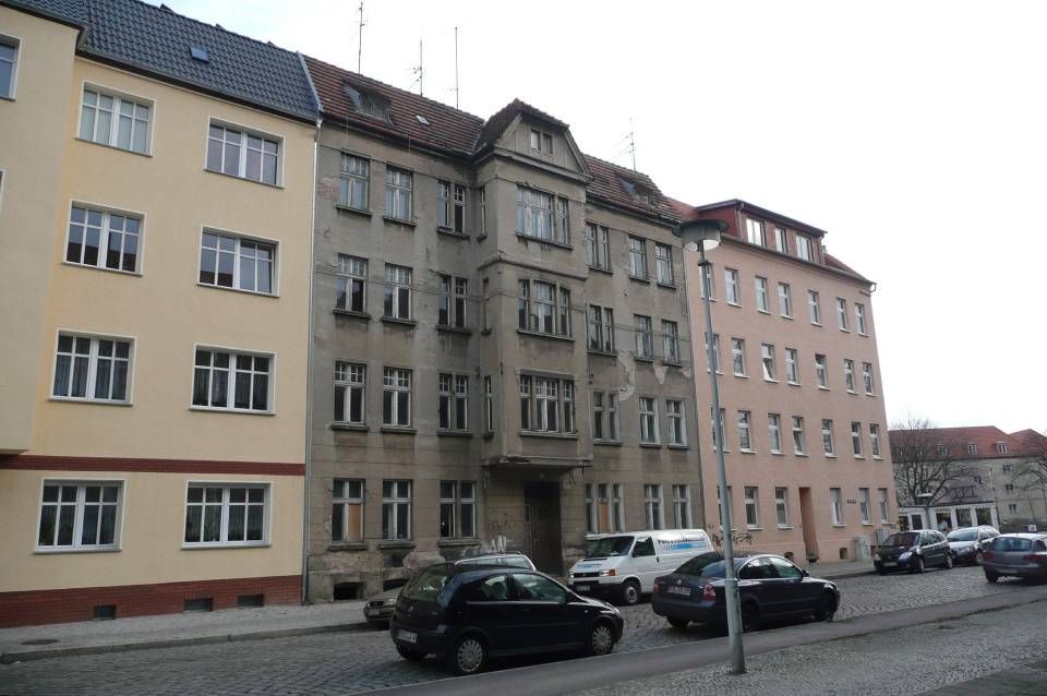 unsanierter  Altbau zwischen zwei frisch sanierten und Fassaden neu gestrichenen Altbauhäusern.