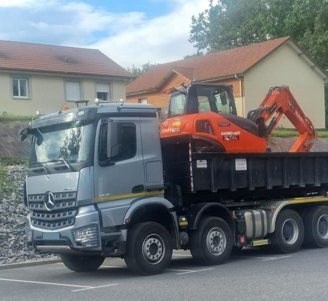 Une minipelle orange sur un camion