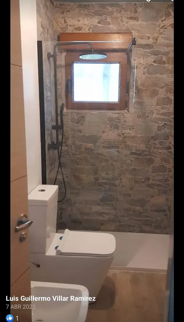 Un baño con inodoro, lavabo y ducha.