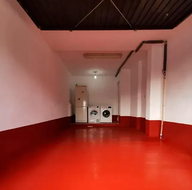 Un lavadero con pisos rojos y paredes blancas.