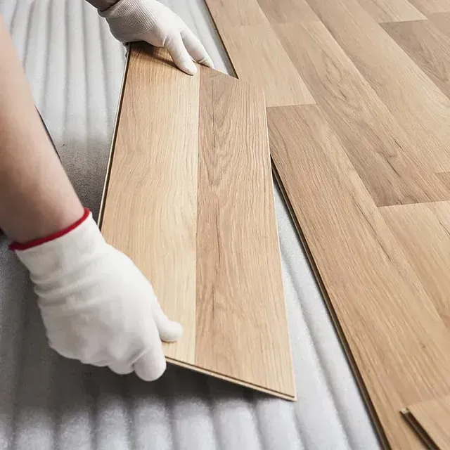 Una persona que lleva guantes blancos sostiene un trozo de madera.