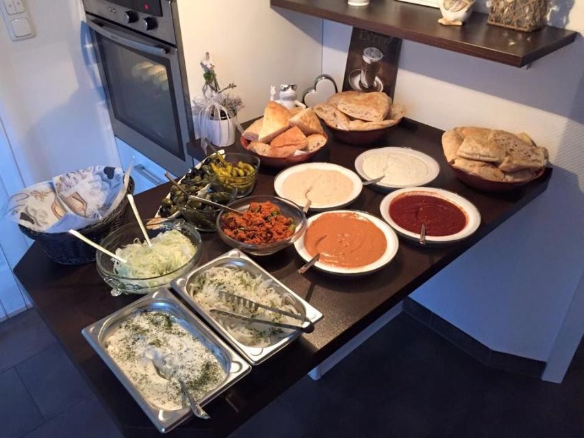 Tisch mit Fladenbrot, verschiedenen Saucen und Dips und Gemüse