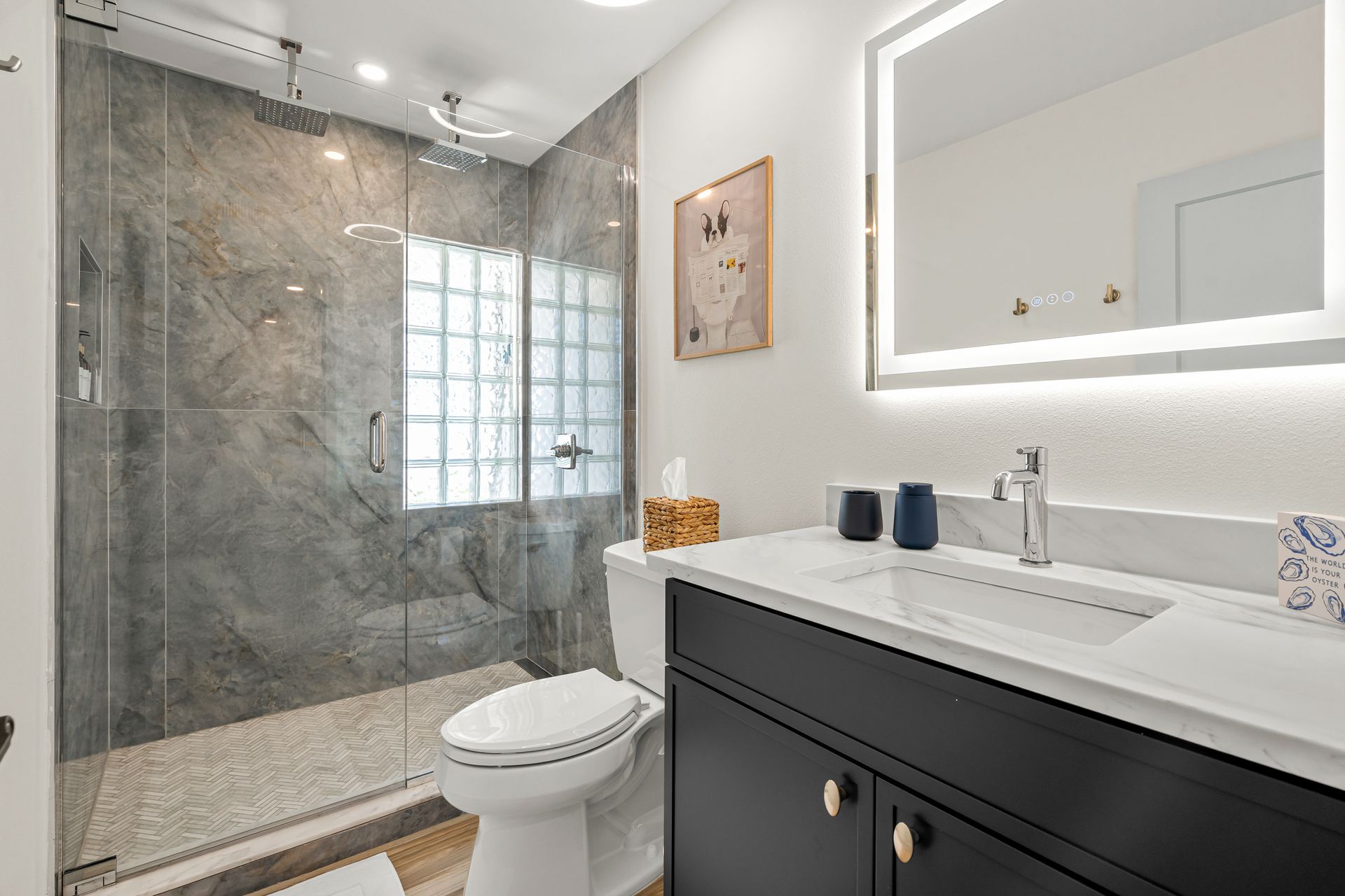 Modern bathroom with glass shower, white vanity, and large mirror