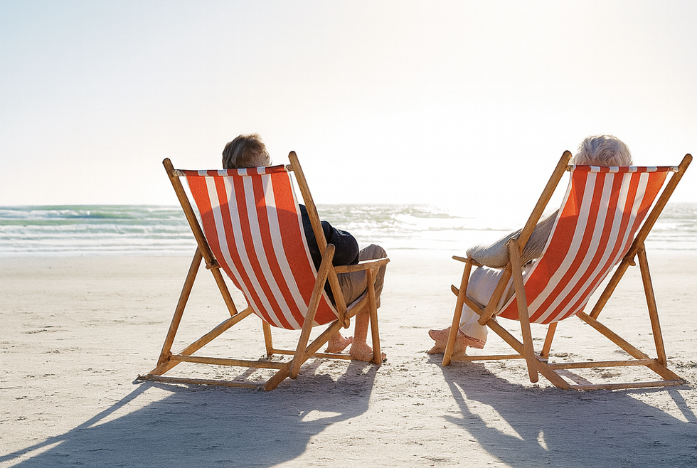 Two striped beach chairs facing the ocean on a sunny sandy beach