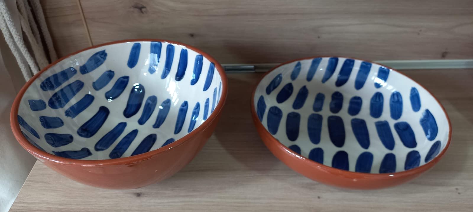 Dos cuencos de cerámica con dibujo de pinceladas azules sobre fondo blanco, colocados sobre una superficie de madera.