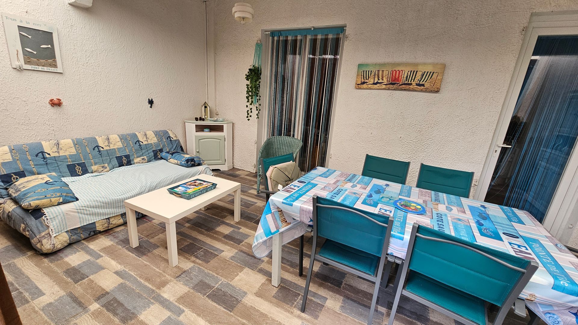 Espace de vie avec canapé, table, chaises et éléments décoratifs ; palette de couleurs bleue et blanche.