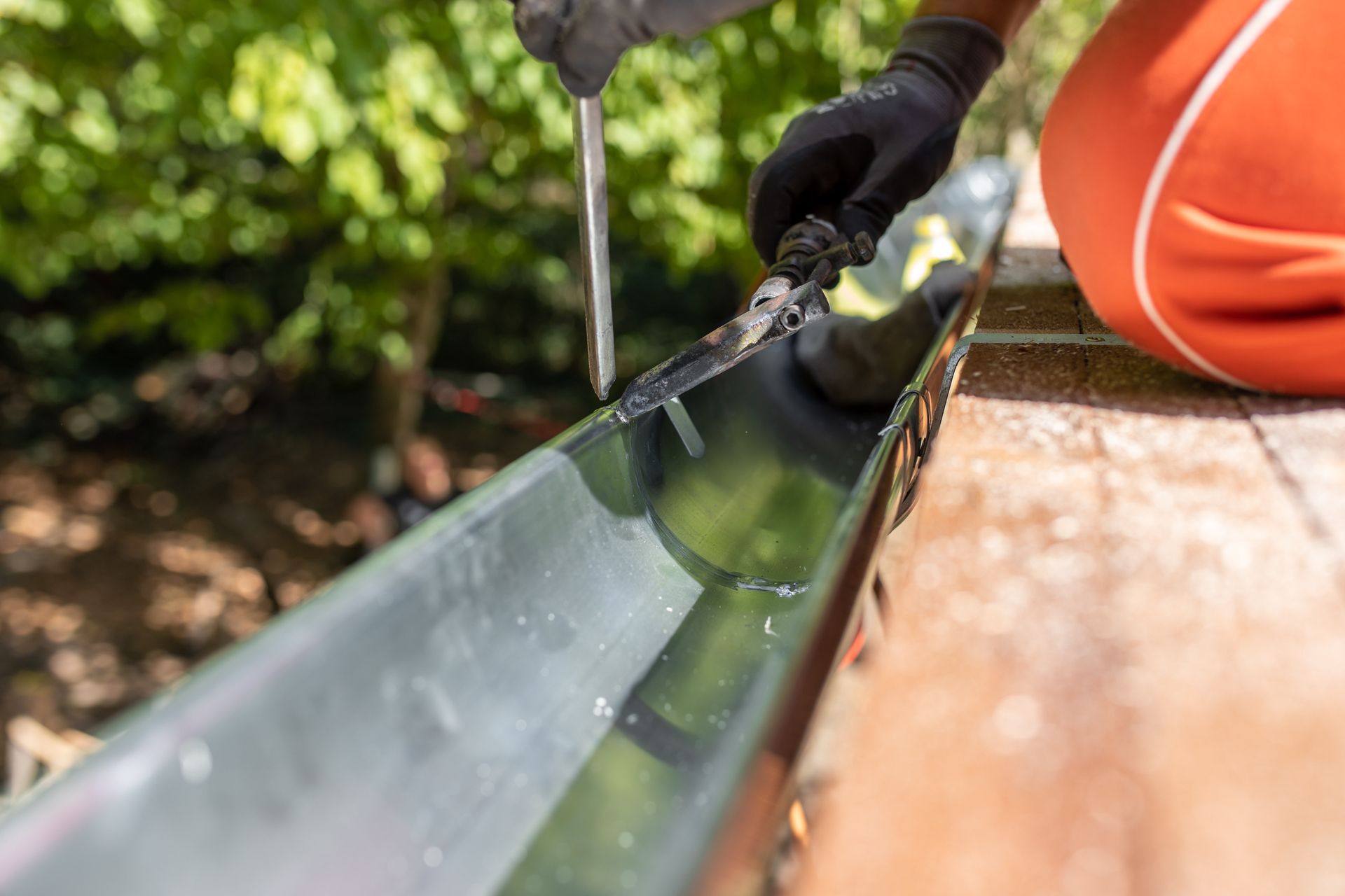 Professionnel qui fixe une gouttière