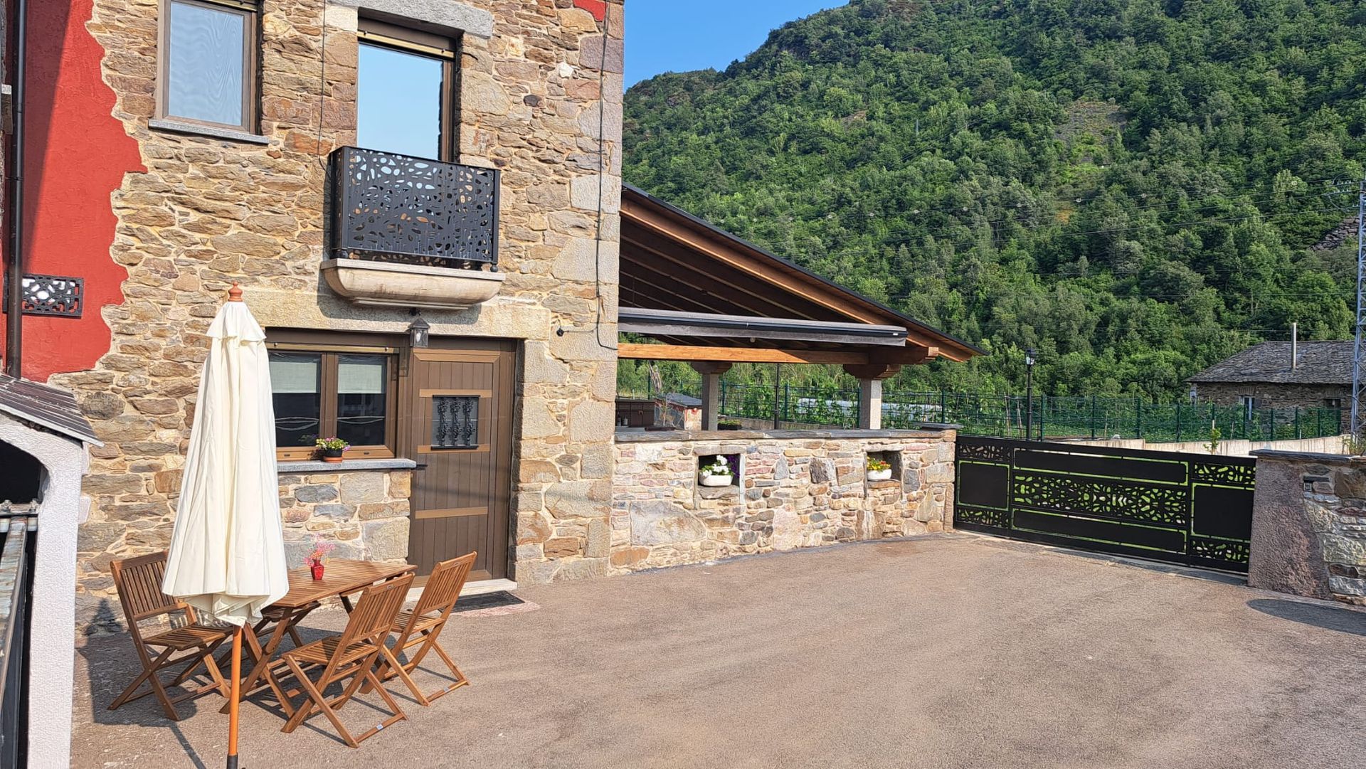Casa de piedra con zona de estar al aire libre y vistas a la montaña.