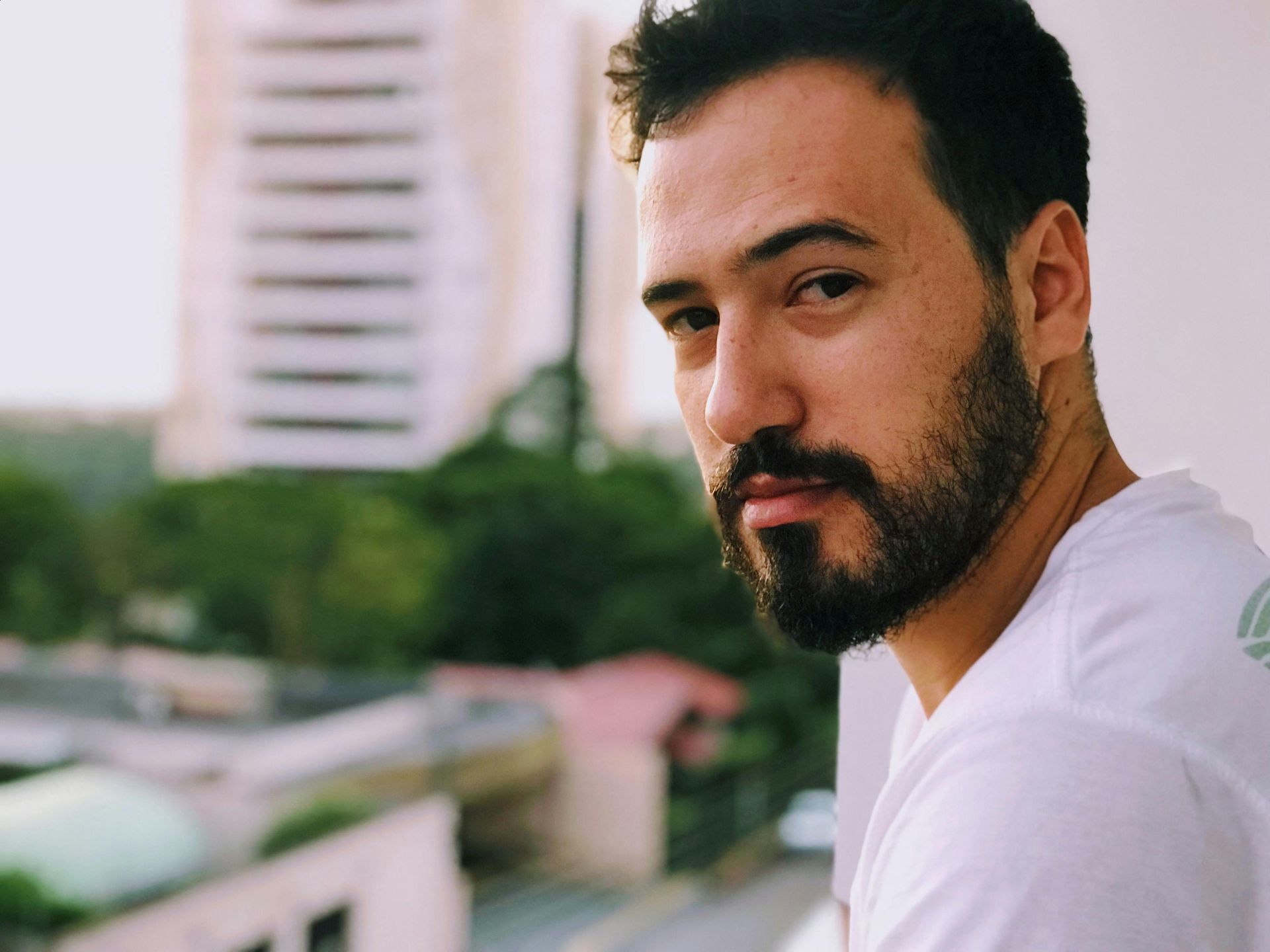 Un uomo con la barba indossa una camicia bianca