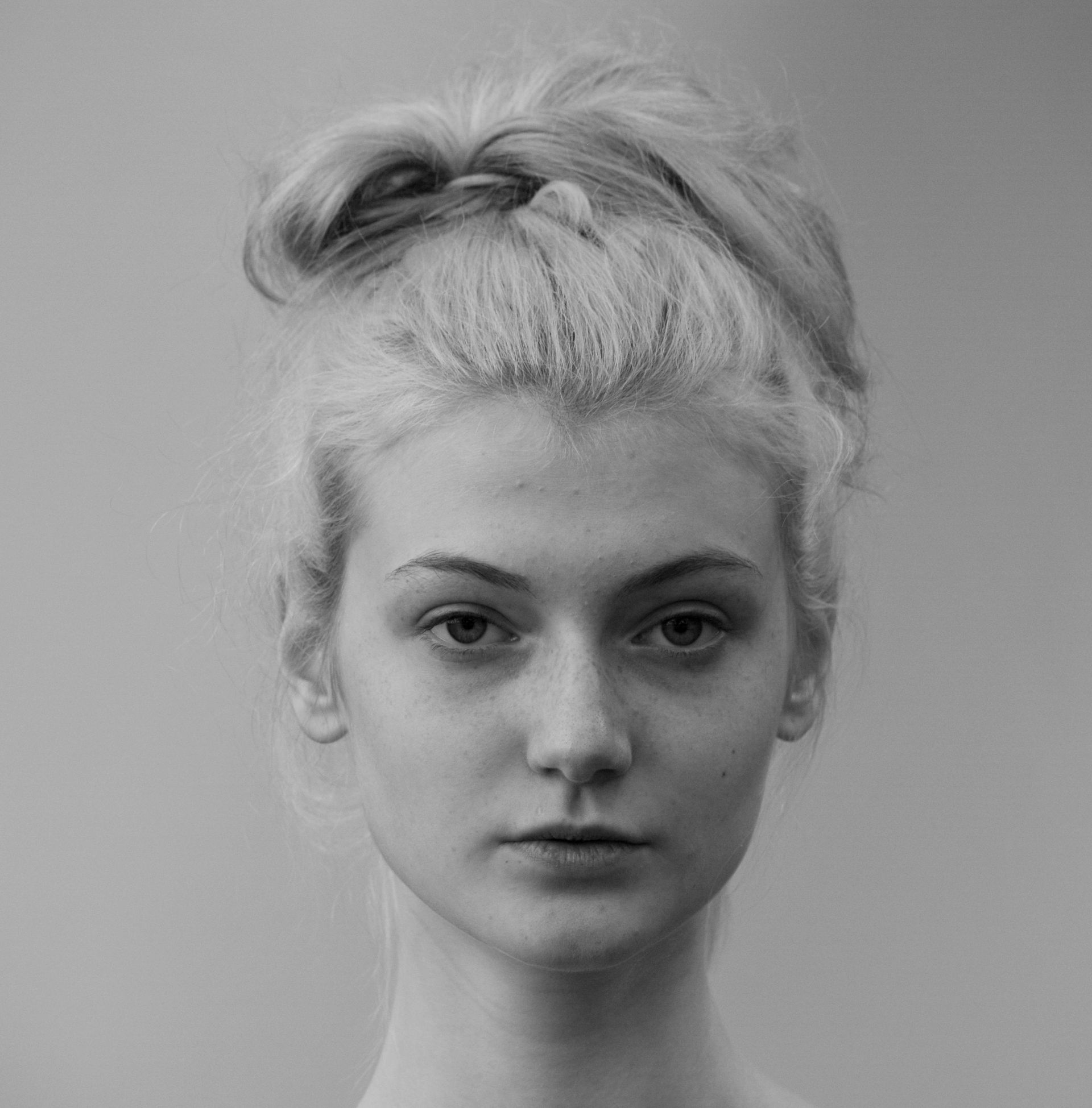 Una foto in bianco e nero di una donna con i capelli raccolti in uno chignon.