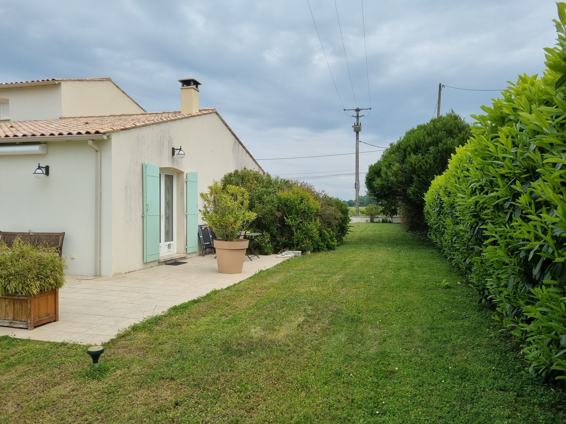 Côté d'une maison avec des volets verts