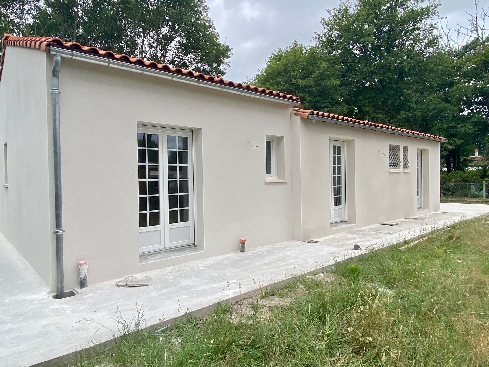 Arrière de la maison avec une terrasse en béton tout le long