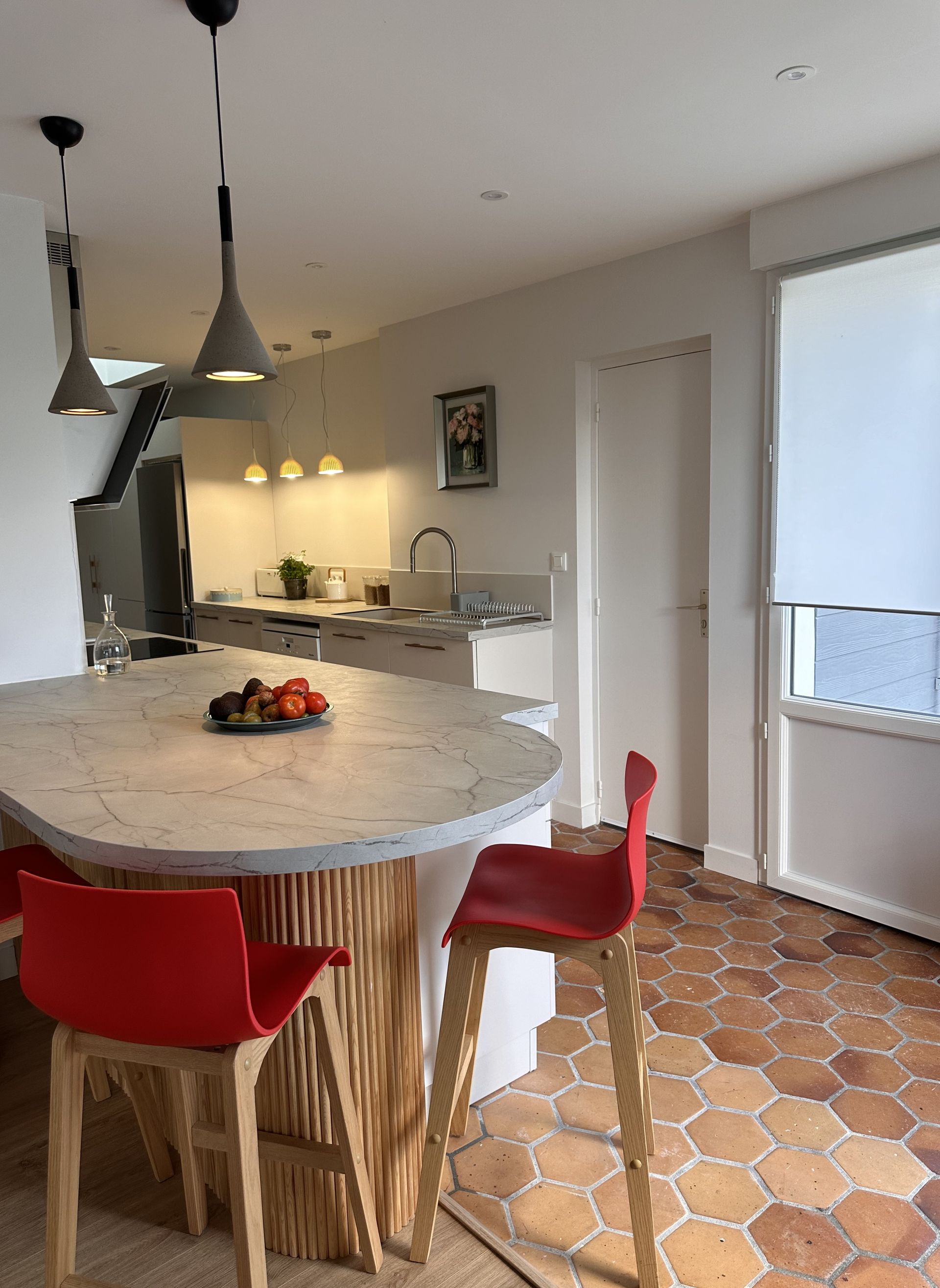 Une table haute avec deux chaises rouges