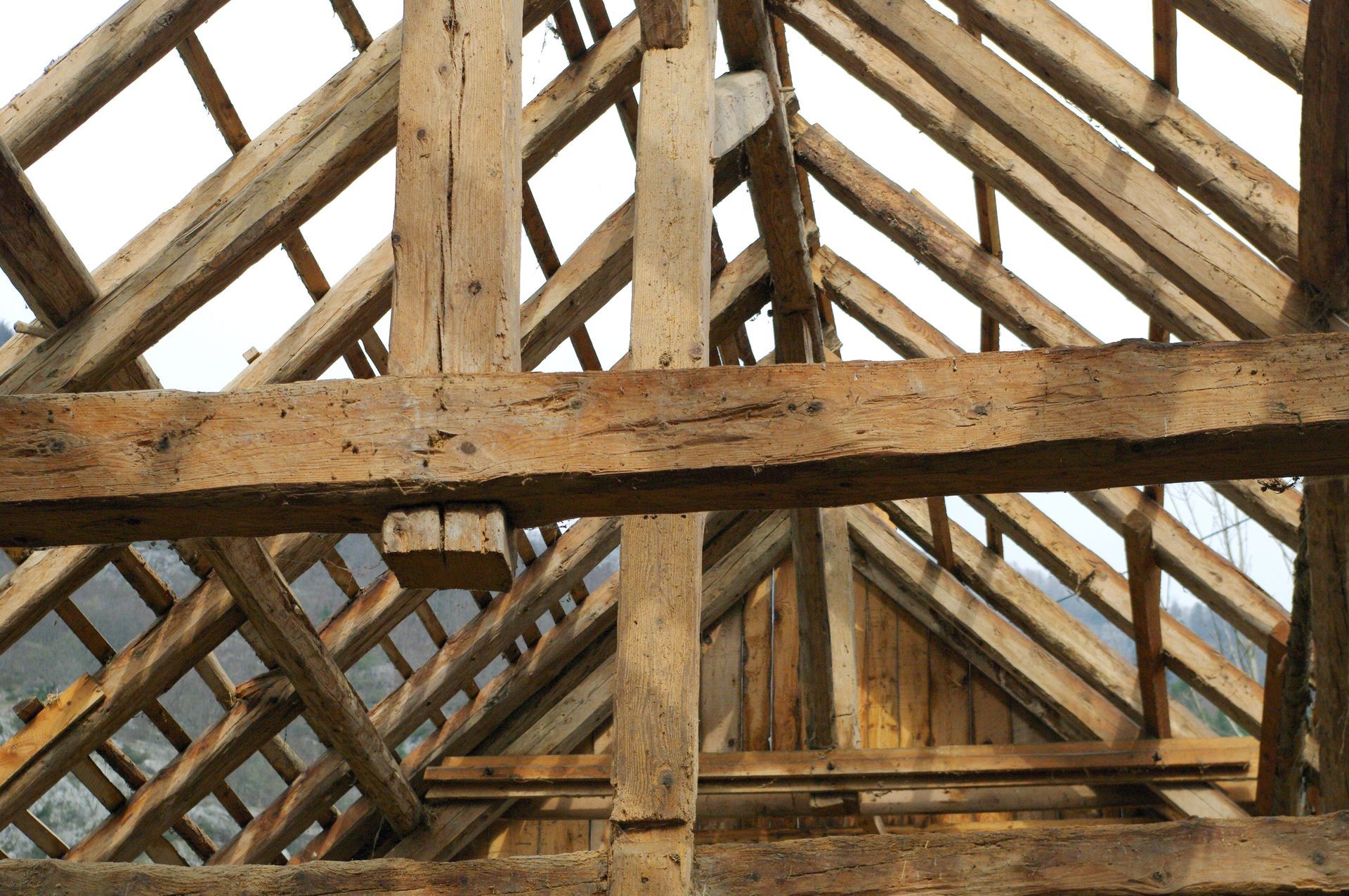 Rénovation de charpente en bois traditionnelle, avec poutres et chevrons apparents.