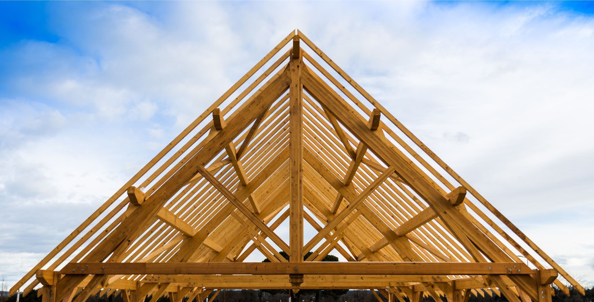 Charpente traditionnelle en bois avec assemblage de fermes et liteaux.