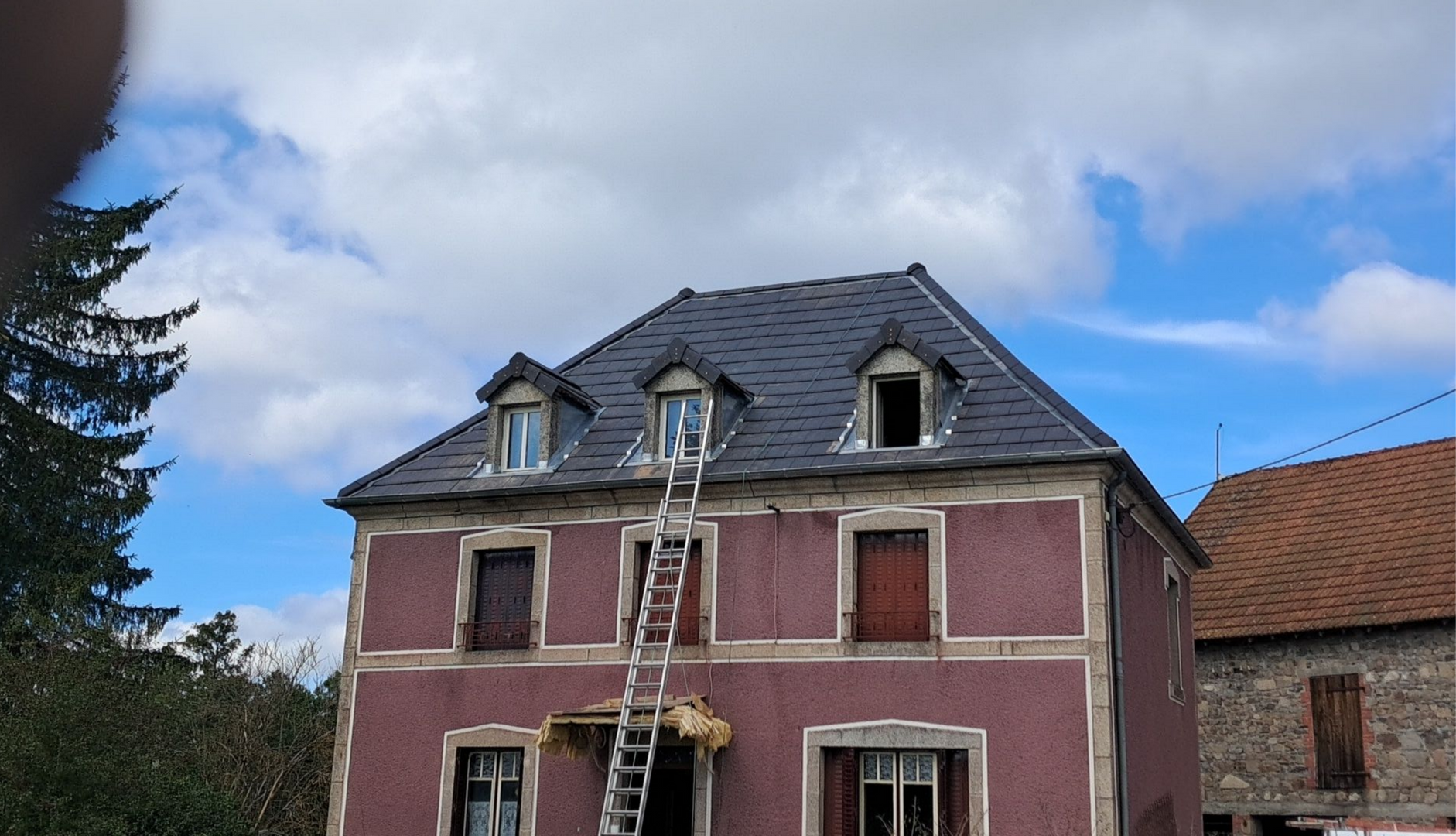 Tuiles de toit en terre cuite endommagées, avec une section cassée et une sous-couche exposée.
