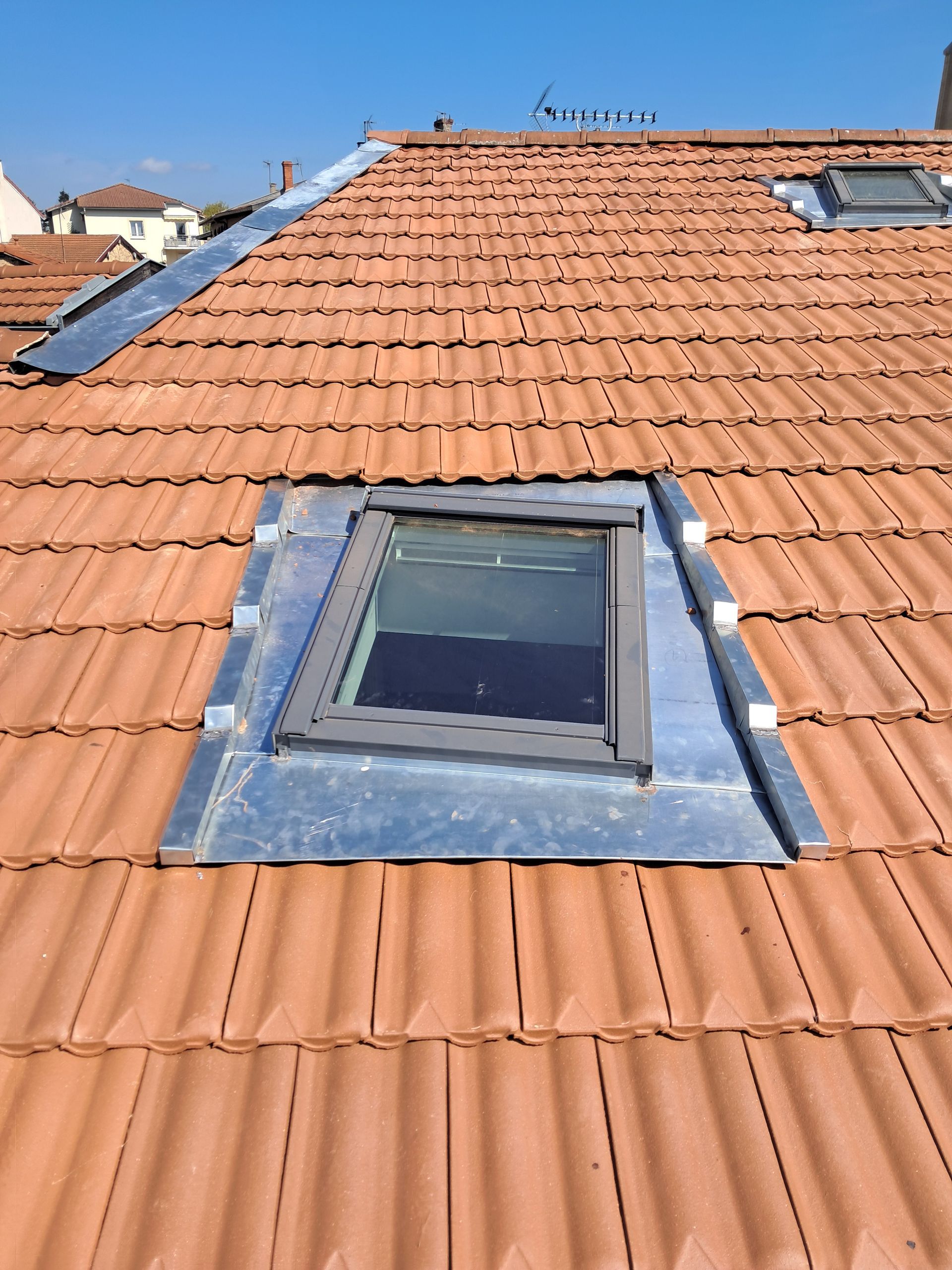 Travaux de pose de fenêtre de toit avec ouverture basculante.