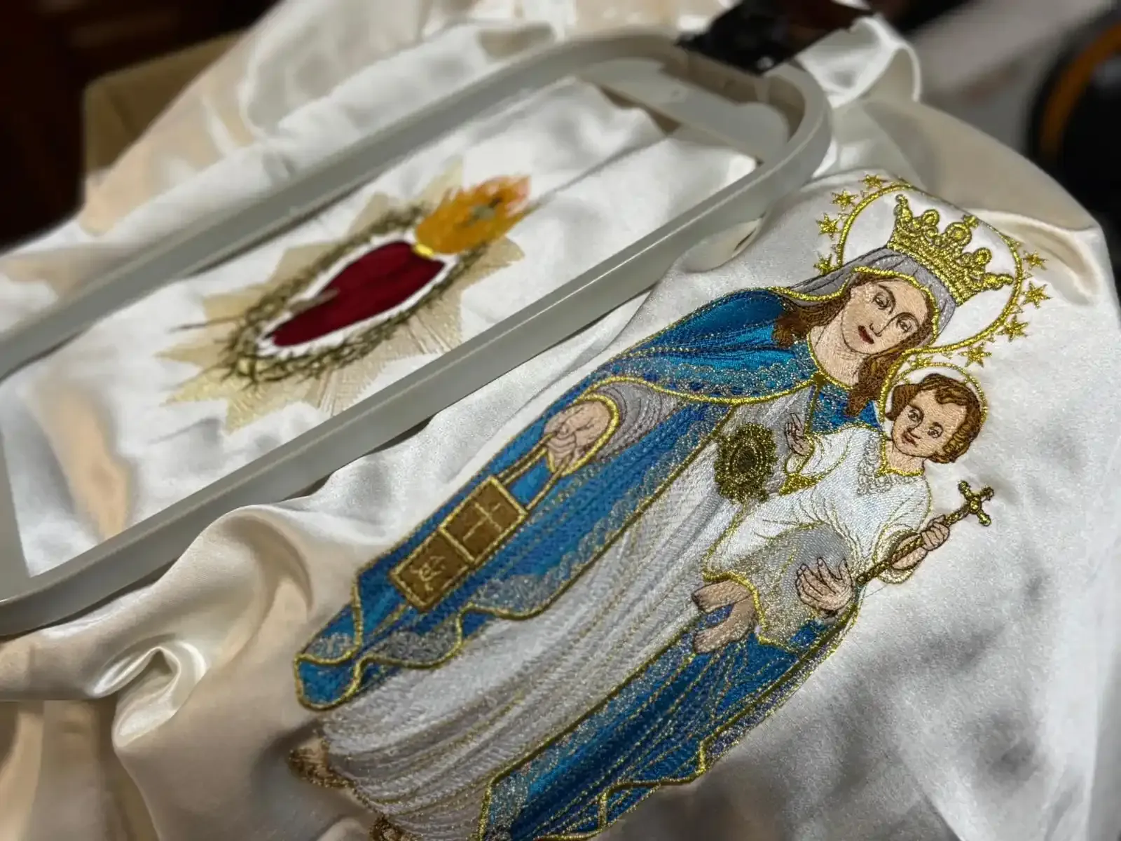 Bordado en proceso: Virgen María y Jesús, más diseño del sagrado corazón, sobre tela blanca en bastidor.