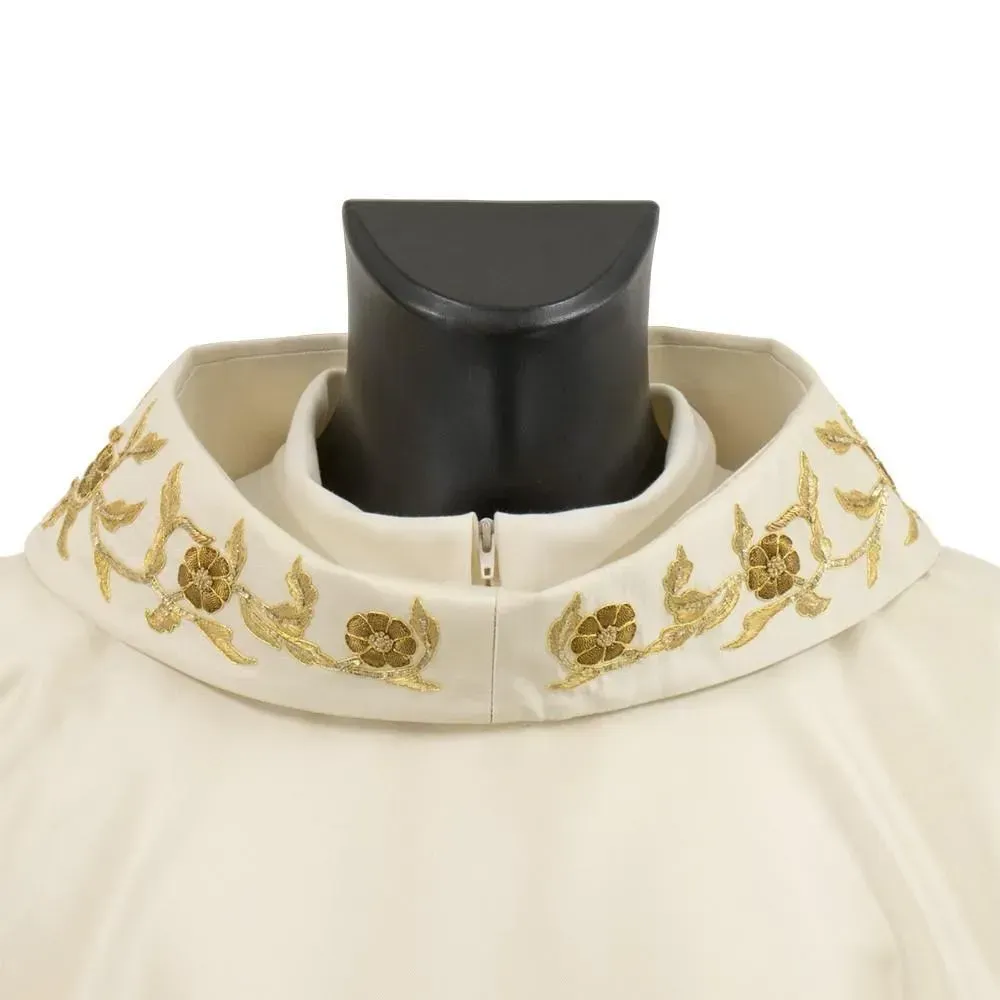 Vestidura clerical de color crema con bordado floral dorado alrededor del cuello, sobre maniquí negro.
