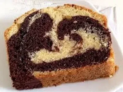 Rebanada de pastel marmolado que muestra un patrón de remolinos de chocolate y vainilla.