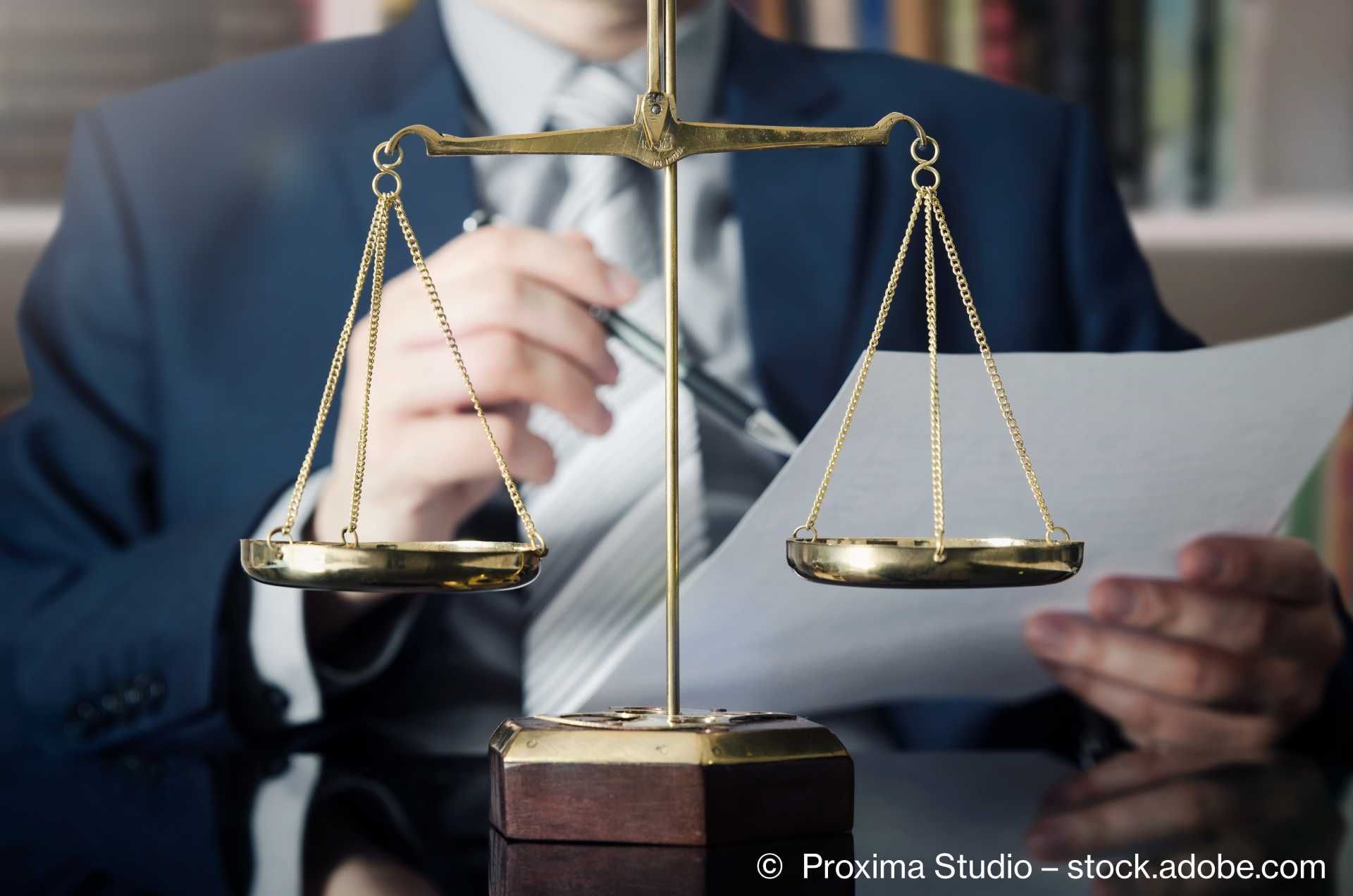 Rechtsanwalt mit Waage im Vordergrund