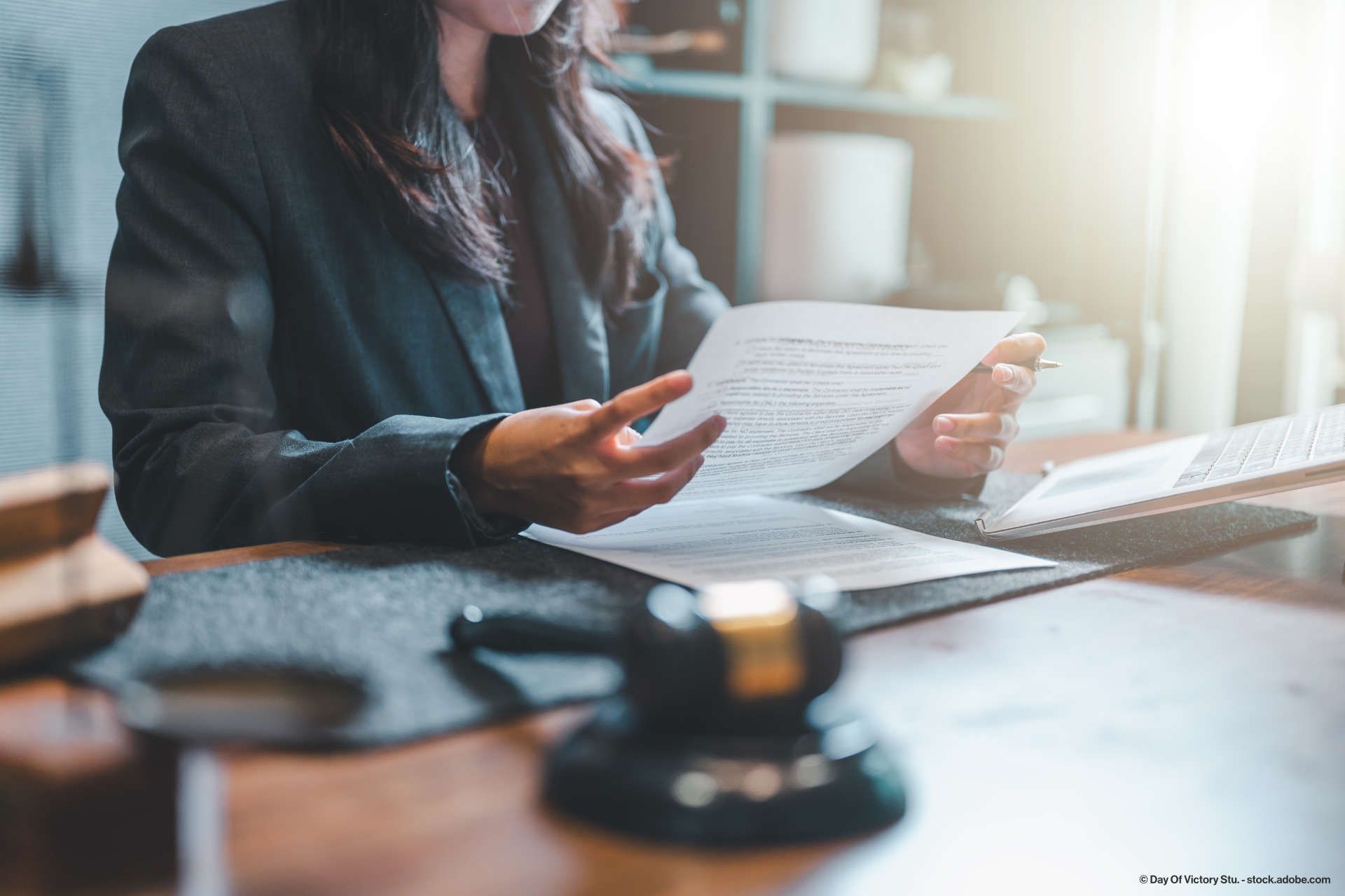 Rechtsanwältin lehnt sich an eine Wand