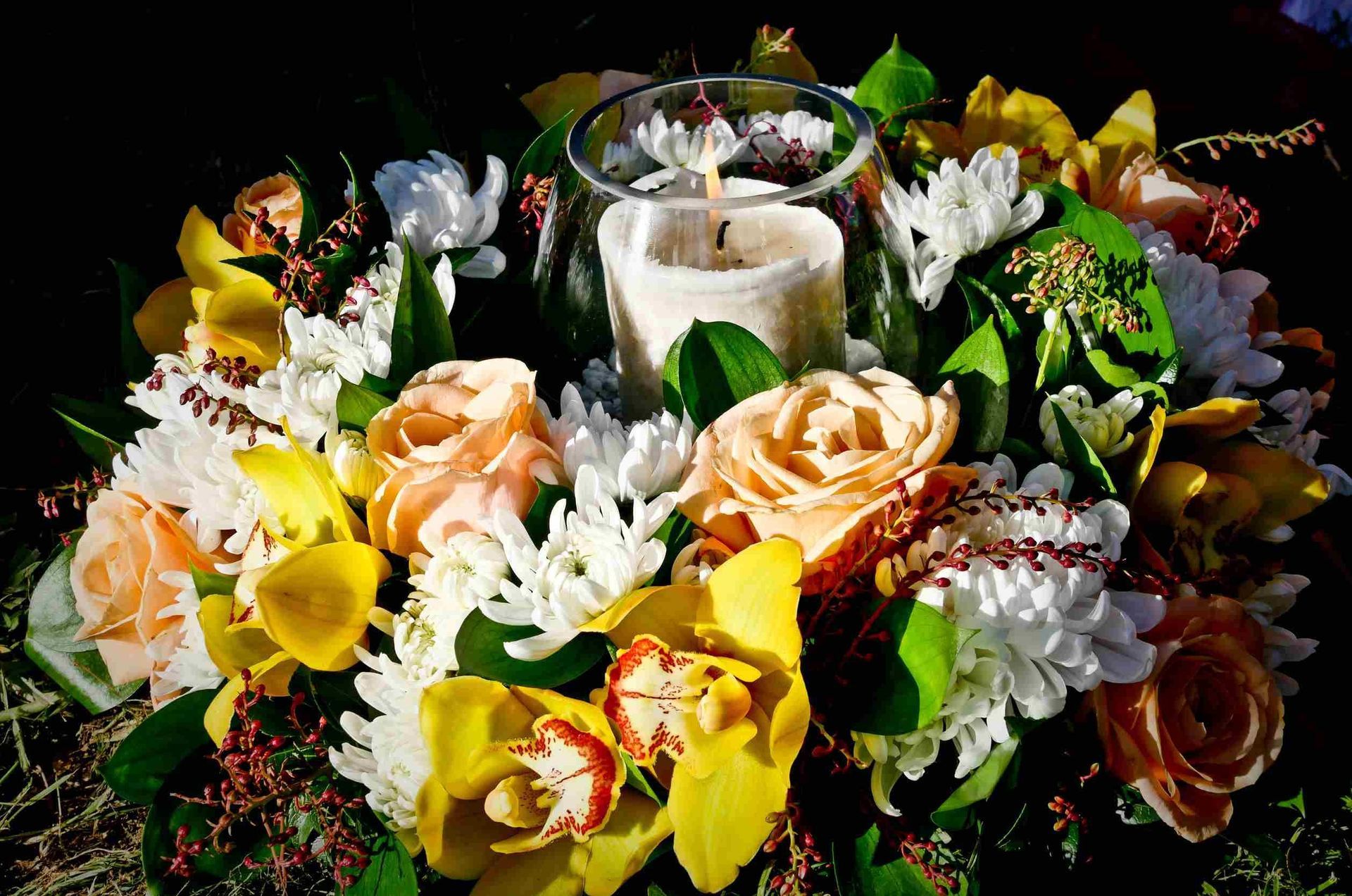 Un ramo de flores con una vela en el medio.